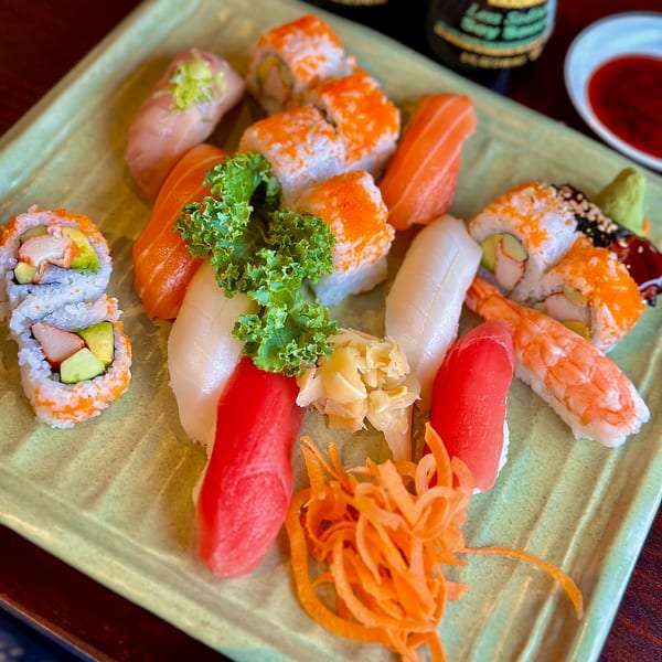 A vibrant platter of assorted sushi and sashimi, including California rolls, tuna, salmon, and shrimp.