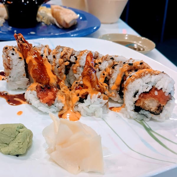 Lim Dynasty Asia Cafe & Xpress sushi roll with shrimp tempura, spicy sauce, wasabi, and ginger.