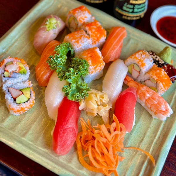 A vibrant platter of assorted sushi and sashimi, including California rolls, tuna, salmon, and shrimp.